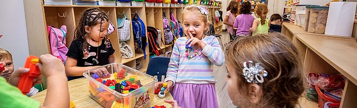 Viele Kinder beschäftigen sich in einer Kita mit Spielzeug.